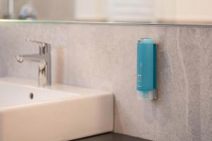 a soap dispenser on a wall next to a sink at Luisl Hof - Apartment Herbae in Cornaiano