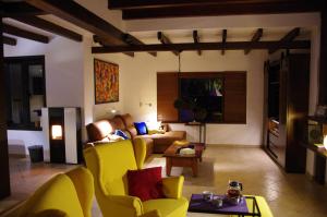 a living room with yellow chairs and a couch at Villa Haere Mai in La Asomada