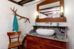a bathroom with a sink and a mirror and a chair at Ferien auf der Fleischdielte in Mühlenbach +25 photos
