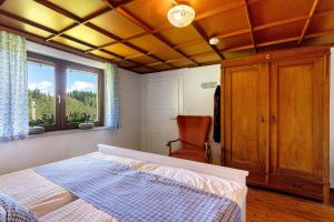 a bedroom with a bed and a chair and a window at Ferien auf der Fleischdielte in Mühlenbach