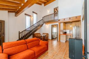 a living room with a couch and a staircase at La Dehesa de Santa Ursula in Espeja de San Marcelino