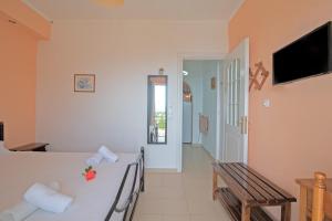 a room with a bed and a television and a hallway at Andromaches large apartment 2 in Corfu