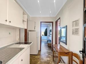 a kitchen with white cabinets and a wooden table at Andromaches large apartment 2 in Corfu