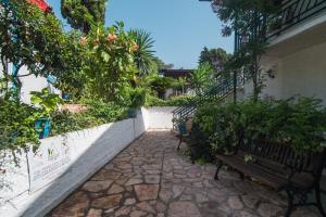 a walkway with benches and plants on a building at Andromaches large apartment 2 in Corfu