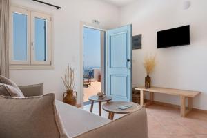 a living room with a couch and a table at Lefkanthemo Apartment in Astypalaia