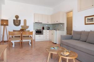 a living room with a couch and a table at Lefkanthemo Apartment in Astypalaia