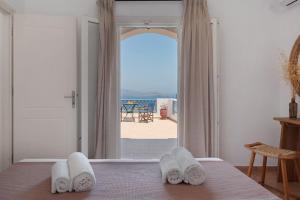 a bedroom with a bed and a view of the ocean at Lefkanthemo Apartment in Astypalaia
