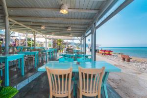 a restaurant with blue tables and chairs on the beach at Mirage Arillas Studio Type A3 in Arillas