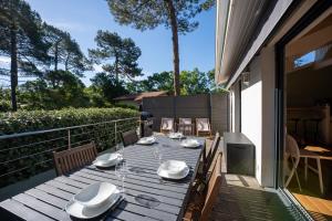 a wooden table on the balcony of a house at Seignosse Le Penon, maison Patio in Seignosse