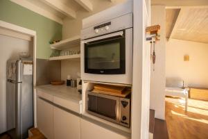 a kitchen with a flat screen tv on a wall at Seignosse Le Penon, maison Patio in Seignosse