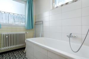 a bathroom with a bath tub and a window at Haus Bernhardt in Langenargen +29 photos