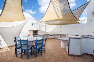 a patio with a table and chairs and a kitchen at Villa Lea in Puerto del Carmen
