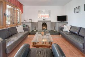 a living room with leather couches and a fireplace at Villa Lea in Puerto del Carmen