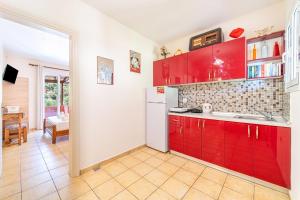 a kitchen with red cabinets and a dining room at Arianna apartment 17 in Paleokastritsa