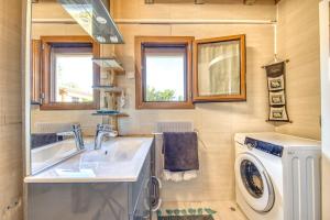 a bathroom with a sink and a washing machine at Maison Les Pieds Dans L'eau in Le Verdon-sur-Mer