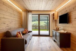 a living room with a couch and a flat screen tv at Archehof Hochzirm Lodge Anton in Campo Tures