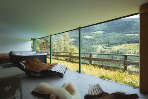 a room with a large window with a mountain view at Archehof Hochzirm Lodge Anton in Campo Tures