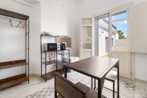 a dining room with a table and a microwave at Luxar Suites and Apartments in Assemini