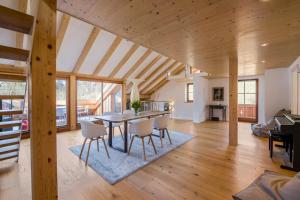 a dining room and living room with a table and chairs at Maisonettewohnung am Wössener See in Unterwössen