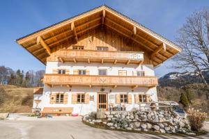 a large wooden house with a large roof at Maisonettewohnung am Wössener See in Unterwössen