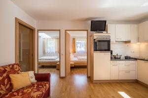 a living room with a couch and a kitchen at Apartment Alpenrose - Mesnerhof in Campo Tures
