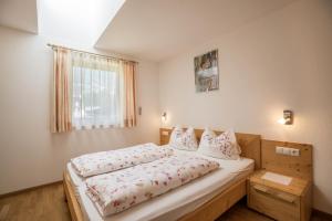 a bedroom with a large bed with a wooden frame at Apartment Alpenrose - Mesnerhof in Campo Tures