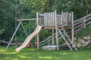 a wooden playground with a ladder and a slide at Apartment Alpenrose - Mesnerhof in Campo Tures