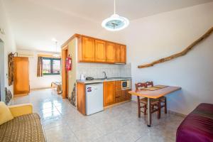 a kitchen with wooden cabinets and a table in it at Mirage Arillas Studio Type A7 in Arillas