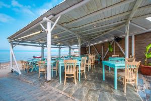 a restaurant on the beach with tables and chairs at Mirage Arillas Studio Type A7 in Arillas