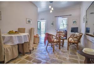 ein Wohnzimmer mit Tisch und Stühlen in der Unterkunft Villa Dendro in Lákka