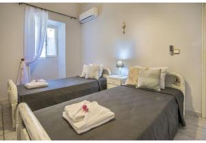 ein Zimmer mit zwei Betten, auf denen Handtücher liegen in der Unterkunft Villa Dendro in Lákka + 14 Fotos