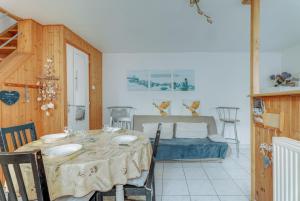 a dining room with a table and a bed at Maison proche Mont St Michel in Pontorson