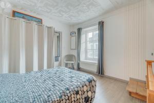 a bedroom with a bed and a large window at Maison proche Mont St Michel in Pontorson