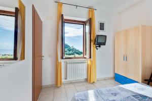 a bedroom with a window and a bed and a tv at Appartamento Ramerino in Pomonte