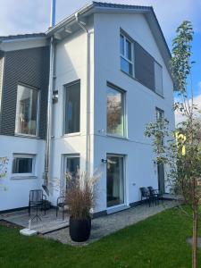 a white house with black chairs in a yard at Feigental in Überlingen +5 photos