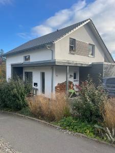 a white house with a car parked in front of it at Feigental in Überlingen
