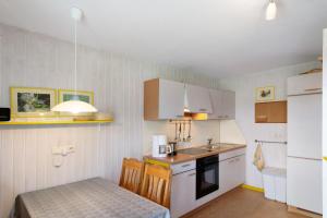 a small kitchen with a small table and a table and a kitchen gmaxwell gmaxwell gmaxwell at Möve Aba Bungalow 60 in Rerik +13 photos