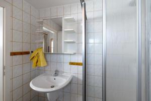 a white bathroom with a sink and a mirror at Möve Aba Bungalow 60 in Rerik