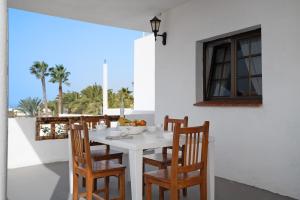 a white dining room with a white table and chairs at La Ratona in Soo