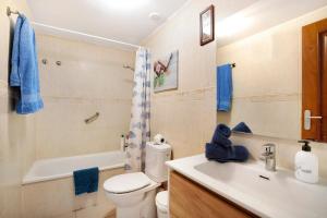 a bathroom with a white toilet and a sink at Ático Los Seres in Los Cristianos +9 photos