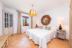 a bedroom with a white bed and a mirror at Villa Rico in Portocolom +20 photos