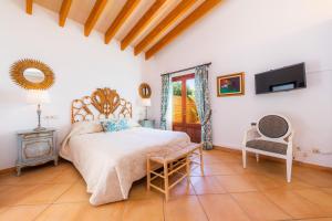 a bedroom with a bed and a tv on the wall at Villa Rico in Portocolom