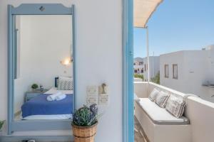 a balcony with a bed and a mirror at Pico Bello Patmos 18 in Patmos