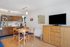 a kitchen with a table and a flat screen tv at Haus Marion in Todtnau