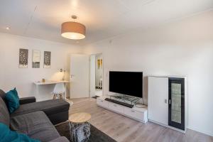 a living room with a couch and a flat screen tv at Ferienwohnung Drachenstein in Weinheim