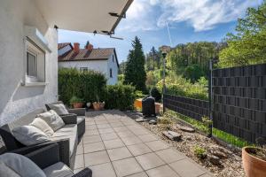 a patio with a couch and a fence at Ferienwohnung Drachenstein in Weinheim