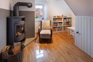 a living room with a fireplace and a chair at Ferienwohnung Omi Anni in Schlitz