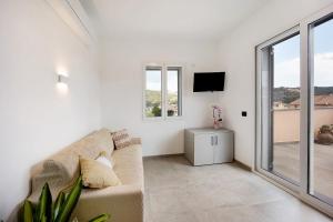 a white living room with a couch and a tv at Antichi Ricordi - Le Giare in Marina di Andora