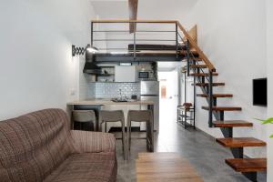 a living room and kitchen with a spiral staircase in a house at Mariola in Novo Sancti Petri