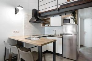 a kitchen with a wooden table and a stainless steel refrigerator at Mariola in Novo Sancti Petri